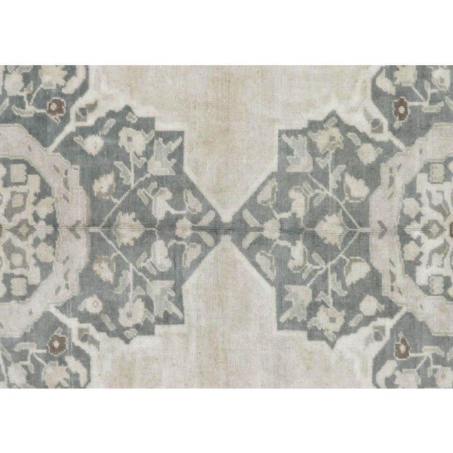 A vintage Turkish Oushak measuring 4'11" x 10', hand-woven with wool on wool foundation. This piece displays the region's...