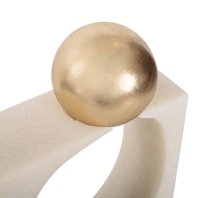 Modern and sculptural, these geometric figures feature white stone bases with striking gold spheres. A bold statement for...