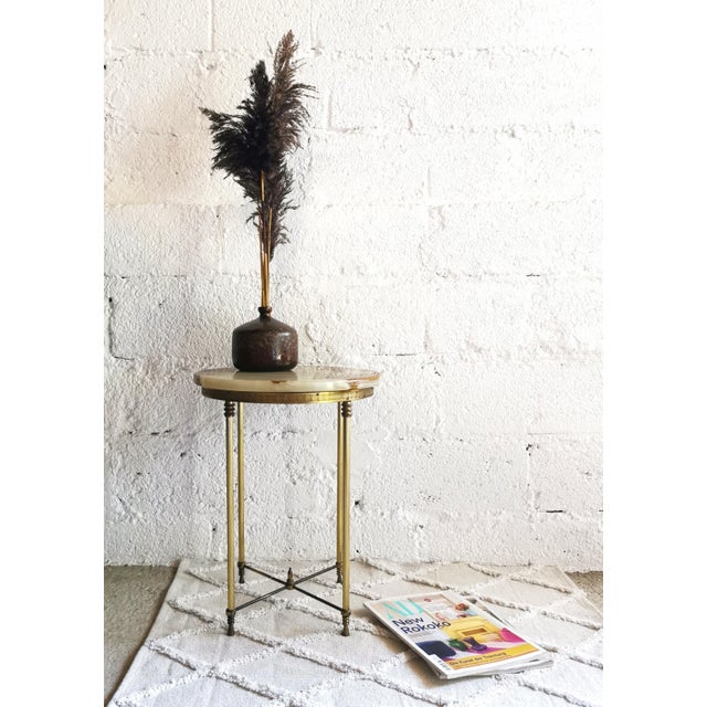 This round side table was made in the 1960s in the Hollywood Regency style. The frame is made of gold-colored metal and...
