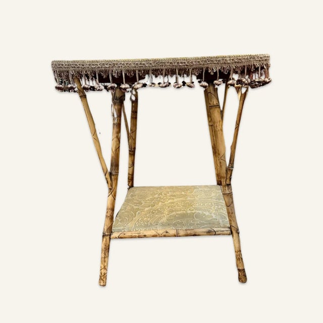 Victorian bamboo side table with tassels covered in Fortuny fabric. This table is structurally sound. The fabric and the...