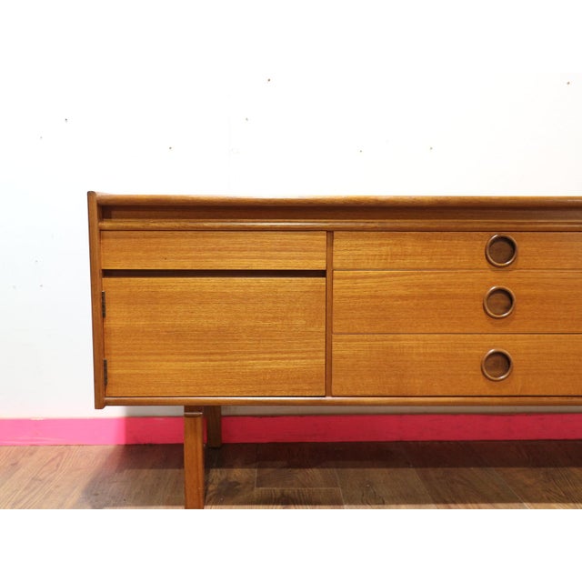 Discover the elegant Mid Century Modern Vintage Teak Credenza Sideboard, in the style of renowned British furniture maker...