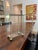 Vintage brass and glass tabletop display case with a hinged front door, small latch and brass ball feet. Glass panels on...
