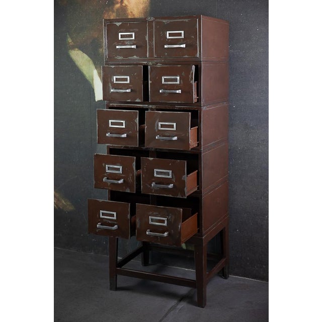 A beautiful, simple filing cabinet with 10 drawers on a plinth by Strafor. The construction consists of stacked modules,...