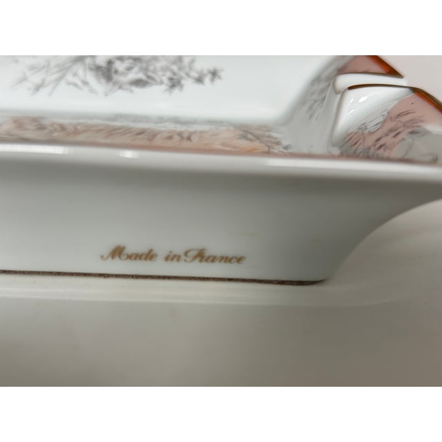 Hermès Limoges porcelain ashtray. Dog/dachshund design with a finely gold-painted rim. Marked "Hermès Paris" on one side...