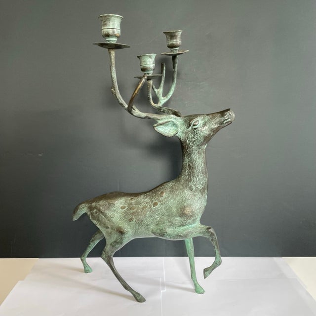 This is a mid century bronze deer candle holder. The standing buck deer has candle holders entwined in its antlers. The...