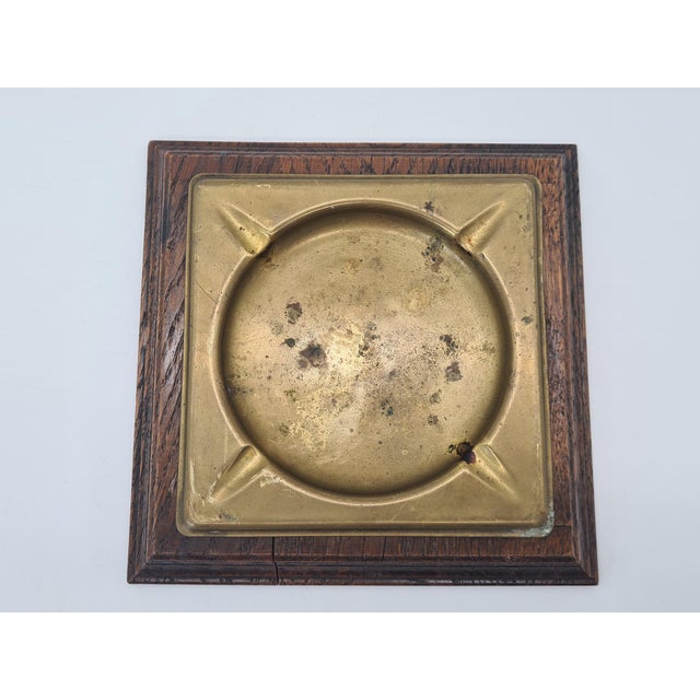 An original, vintage ashtray made of brass set in a solid oak base, manufactured by the renowned Dutch company...