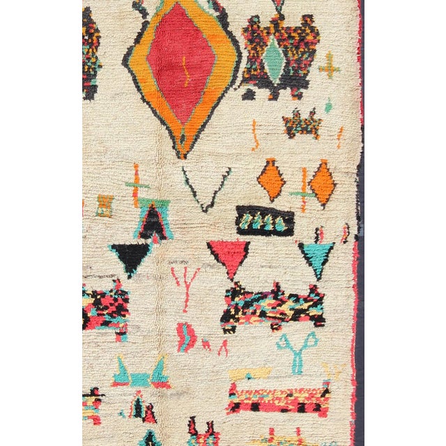 This Moroccan carpet offers comfort and warmth with a neutral field and vivid color palette. Keivan Woven Arts...