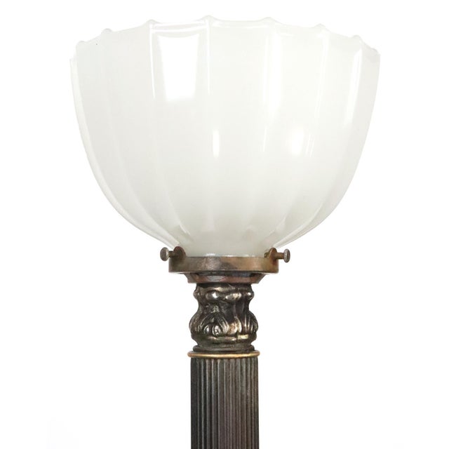 Art Deco style torchiere floor lamp featuring a brass frame with a white veined marble accent at the base and a white milk...