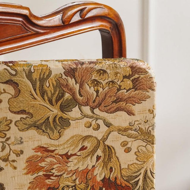 Historic 19th-century fireplace screen, circa 1880, featuring an upholstered panel and a carved mahogany frame. The...