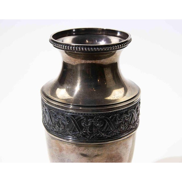 Elegant silver-plated urn-form vase featuring a refined neoclassical silhouette with a gently flared rim, baluster neck,...