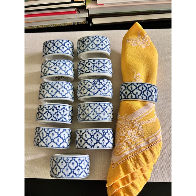 A vintage set of 12 Williams Sonoma porcelain napkin rings with a blue and white lattice pattern. The classic chinoiserie-...
