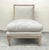 An antique Louis XVI style upholstered slipper chair with a distressed wooden frame and fluted legs. Originally developed...