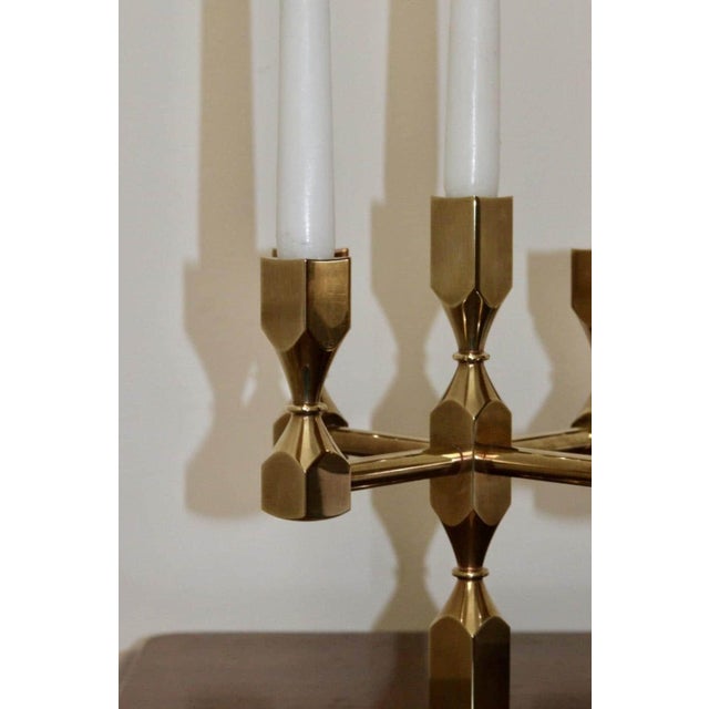 Made in Sweden. This exquisite five-arm candelabra, crafted from solid brass, is a design masterpiece produced by Gusum...