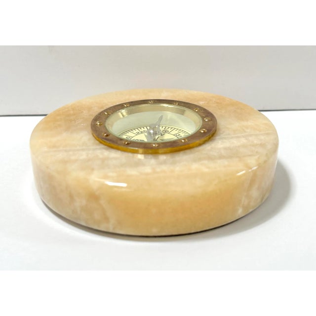 A handsome 1970s marble compass paperweight featuring a polished stone base with an inset brass-toned compass. Decorative...