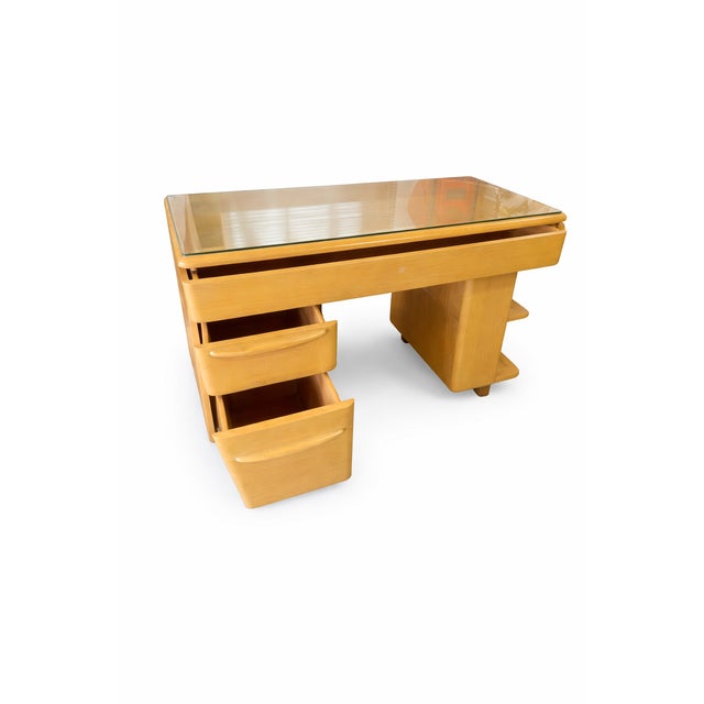 A 1950s Heywood-Wakefield desk in the company’s signature Champagne finish, featuring integrated bookshelves. This piece...