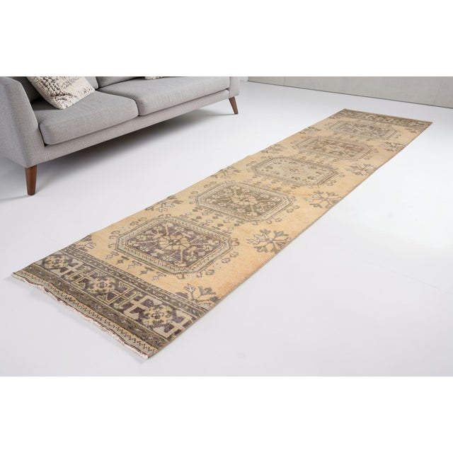 This is a vintage Turkish Oushak rug from the Mid 20th Century. The piece was hand-knotted.