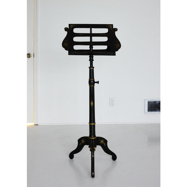 Elegant English 19th Century music stand in ebonized wood, finely decorated with hand-applied gilt motifs and mother-of-...