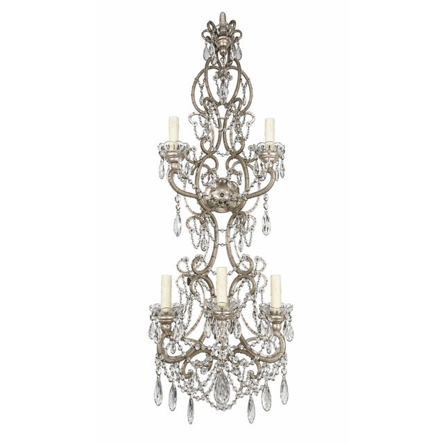 An exquisite pair of mid-20th century Italian wall sconces, masterfully crafted with intricate metalwork and adorned with...