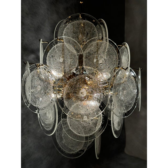 Striking Italian chandelier from the 1970s featuring numerous hand-formed clear Murano glass discs with distinctive...