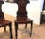 Beautifully carved mahogany hall chairs with armorial backs, hand-turned legs and solid mahogany seats. The chairs with...