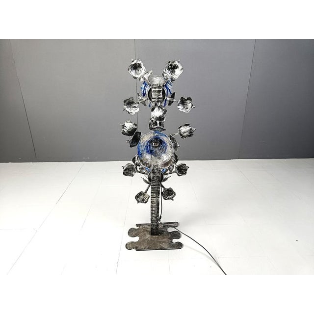 Fantastic Brutalist floor lamp made out of a sculpted flower shaped steel base with blue and clear glass murano glass...