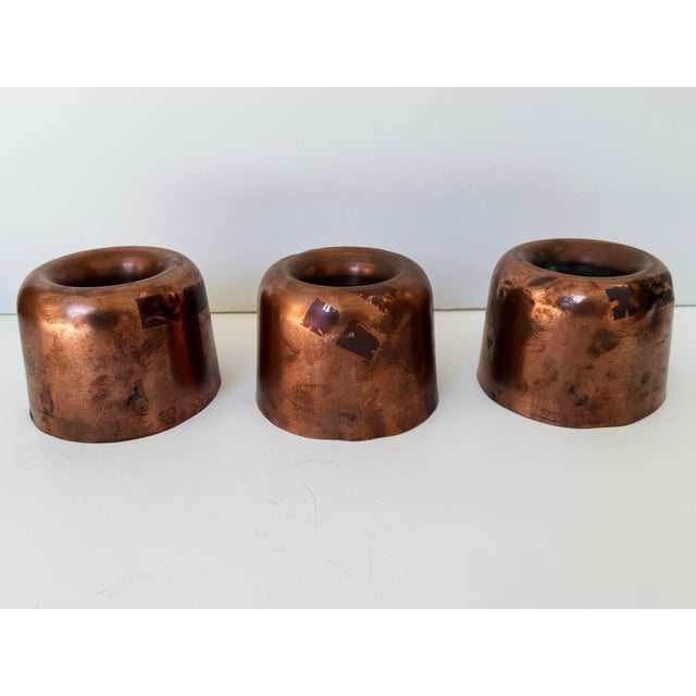 A charming set of three antique English copper culinary moulds, probably Victorian. Their substantial construction and...