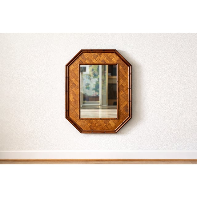 Octagonal wall mirror with parquetry wood frame, late 20th century. Frame constructed with geometric veneer inlay. Warm...