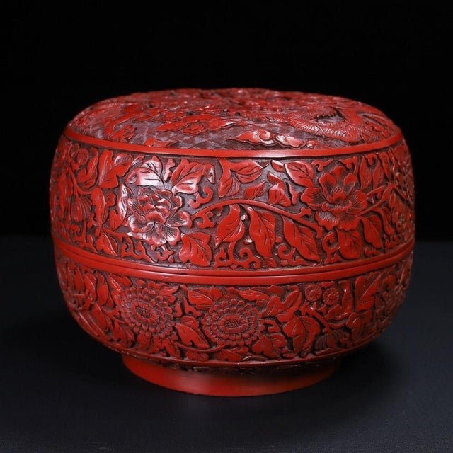 This is a substantial and exquisitely crafted carved lacquer box, featuring deep, intricate relief work in a rich,...