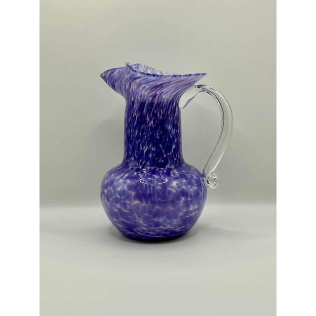 A beautiful Wheaton Village 2000 hand blown glass pitcher vase in rich purple, lavender, white, and blue mottled art...