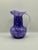 A beautiful Wheaton Village 2000 hand blown glass pitcher vase in rich purple, lavender, white, and blue mottled art...