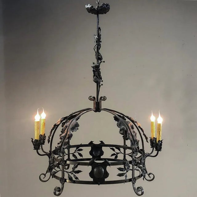 Antique Italian Wrought Iron Chandelier features an intriguing dome shape with heraldic crests, lavish foliates, and four...