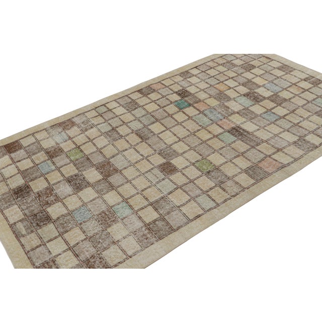 Hand Knotted in wool, this 4x7 vintage Zeki Múren rug originating from Turkey, circa 1960-1970, features a unique play of...