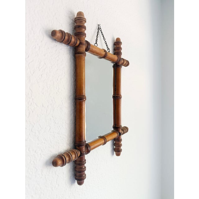 A classic French faux bamboo framed wall mirror with original brass chain hanger and glass. The frame is nicely hand-...