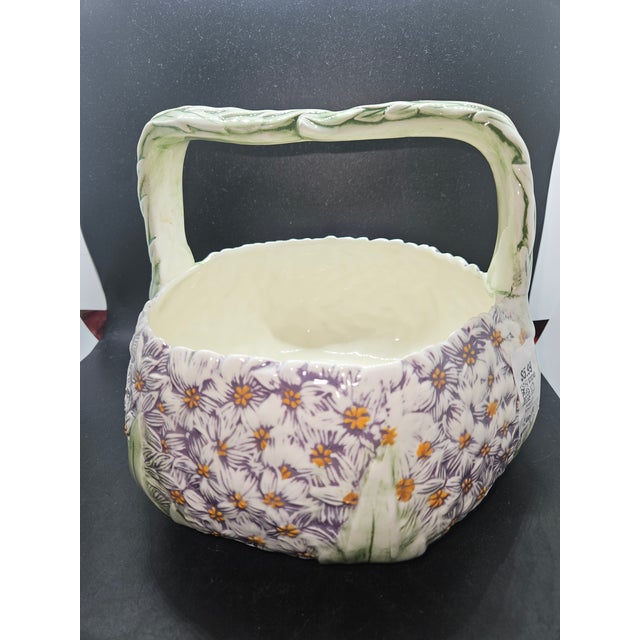 vintage ceramic basket features an embossed purple and white floral pattern with a sculpted twig-style handl