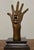 A dramatic solid bronze surrealist hand sculpture, signed by the artist and mounted on a polished black marble base. This...
