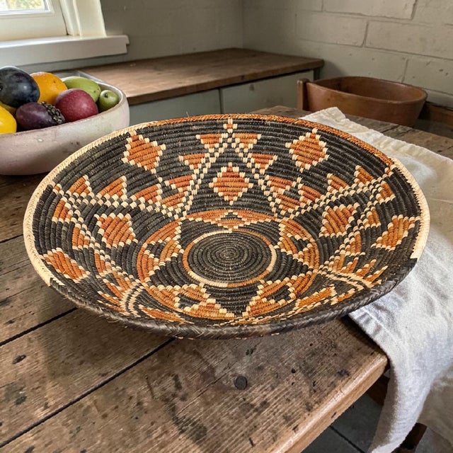 This vintage tribal African Zulu hand-weaved basket originated from South Africa, showcasing traditional craftsmanship and...
