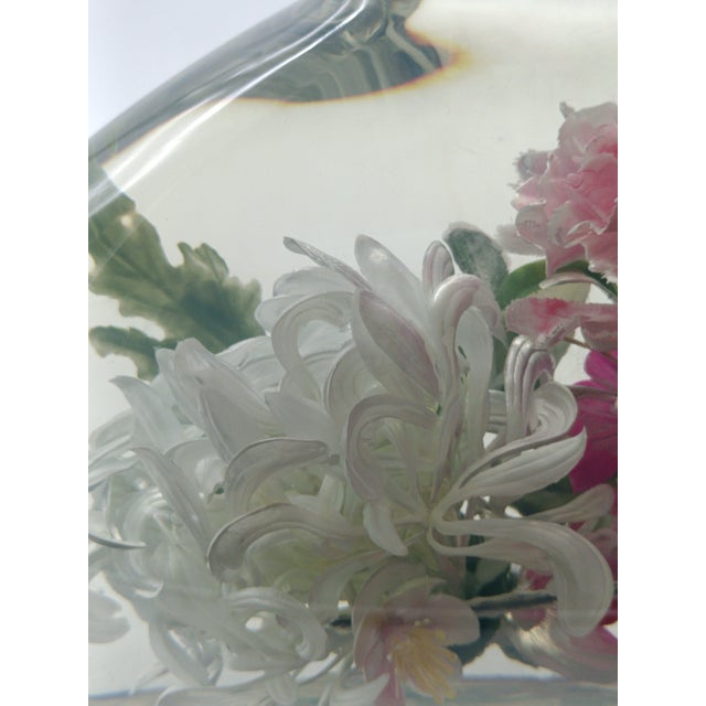 Transparent resin sculpture with embedded plastic flowers and coloured bust-shaped elements. Signed in the lower right...