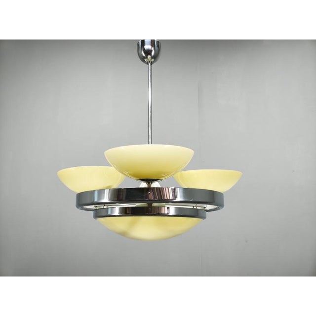 Elegant art deco chandelier produced in czechoslovakia during the 1940s. The pendant combines chrome-plated metal with...