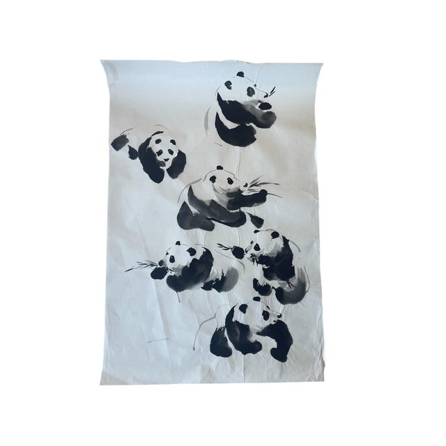 A vintage ink brush painting on rice paper featuring seven pandas in dynamic and expressive poses, rendered in a fluid and...