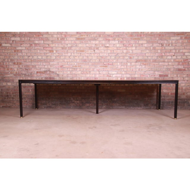 A gorgeous mid-century modern extension dining table By Harvey Probber USA, 1960s Book-matched teak top, with ebonized...