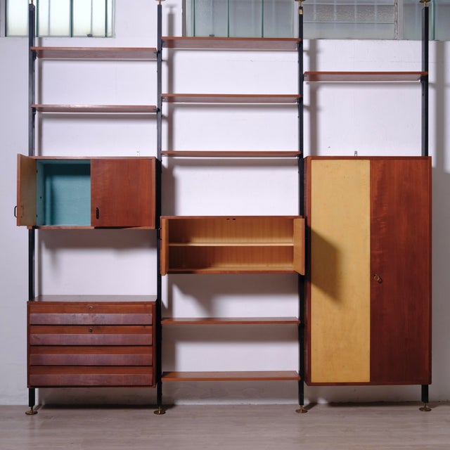 Beautiful wood and metal bookcase, floor-to-ceiling uprights, 1960s design, made in Italy. In the upper left section are:...