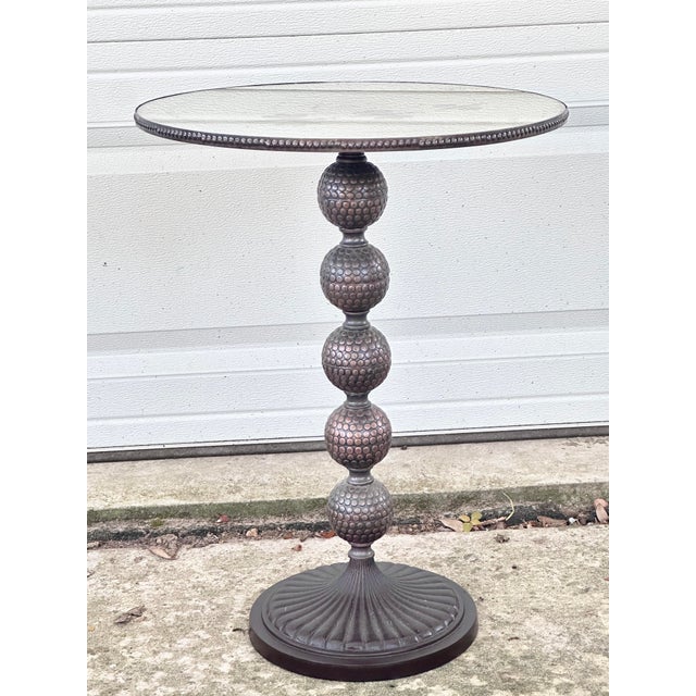 Lovely vintage side table. The base is studded metal in a bronze color. The top features an etched mirror. The mirror has...