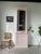 Old wooden display case painted pink. we love its compact, very tall format and its shallow depth. composed of an upper...