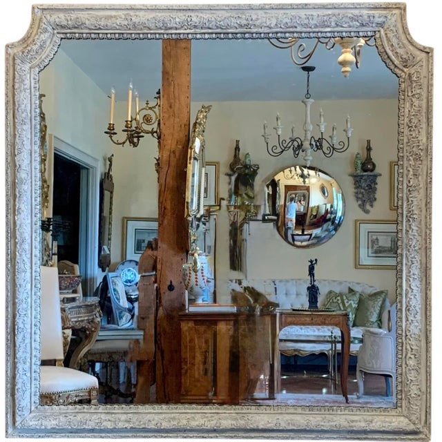A finely carved 18th century French mirror with a weathered pale grey painted finish, the details are beautifully...