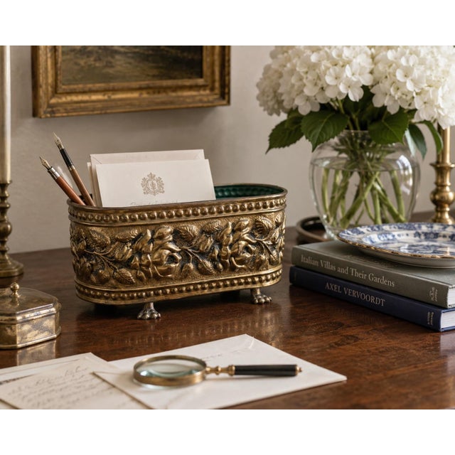 A handsome mid-20th-century English cachepot worked in richly embossed brass with a continuous pattern of full-blown...
