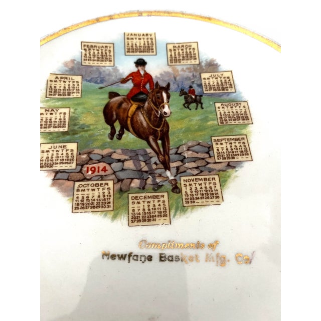 Marvelous 1914 antique calendar plate. Ceramic with gilt trim showing a horsewoman riding English side saddle jumping over...