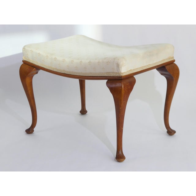 Antique English wooden foot stool with an elegant white fabric. The stool is standing on wooden cabriole legs. Made out of...