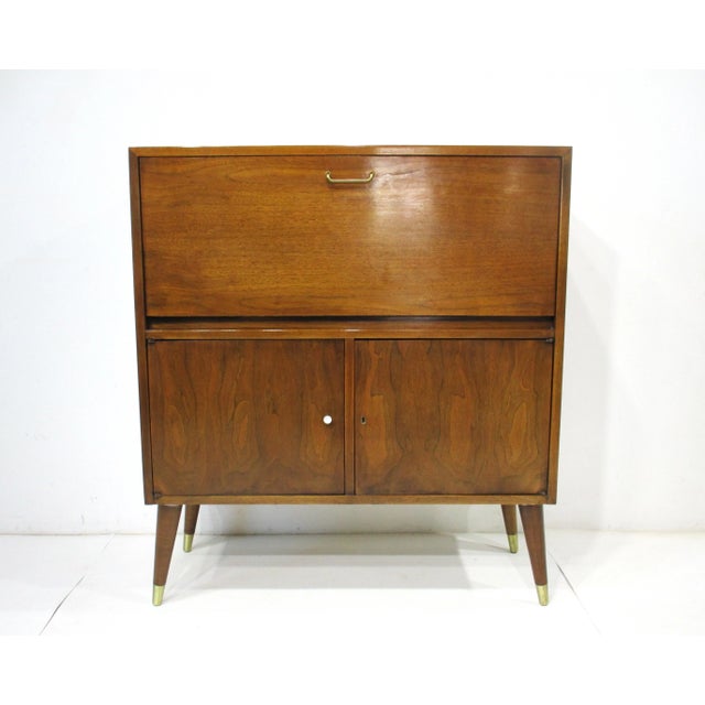 A rare Mid Century Walnut bar cabinet with pull down door making a mixing and serving platform covered in white Laminate ....