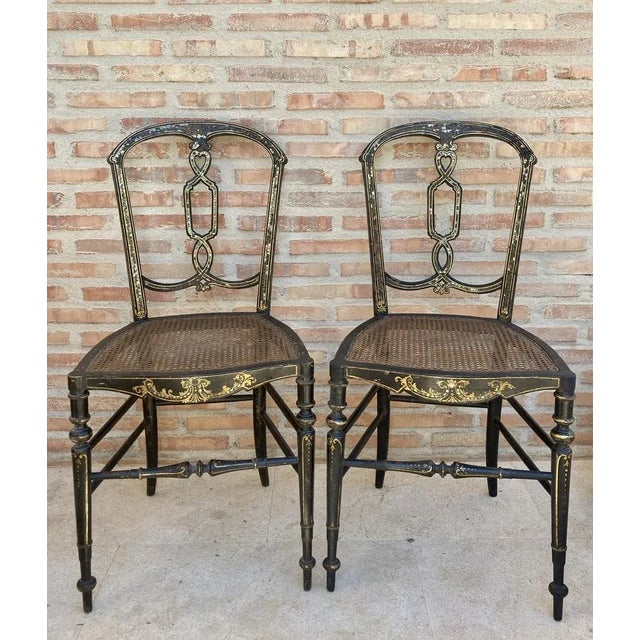 Elizabethan Wood Chairs Lacquered in Black and Decorated in Gold with Wicker Seat, Set of 2 A pair of charming Elizabethan...