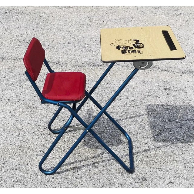 Folding children's desk/study chair made of blue metal, wood, plastic with padded seat and comic book design printed on...
